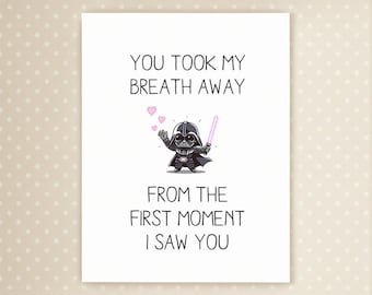 Puede incluir: Tarjeta de felicitación blanca con el texto "YOU TOOK MY BREATH AWAY FROM THE FIRST MOMENT I SAW YOU". Ilustración de Darth Vader con un sable de luz y corazones rosas.