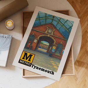 May include: A print of the Tynemouth Metro station, featuring a detailed illustration of the brick building with a clock tower and arched entrance. The print includes the Metro logo and the name "Tynemouth" in black text. The artwork is displayed on a white background.