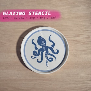 Könnte beinhalten: Ein weißer runder Teller mit einem blauen Rand und einem blauen Kraken-Design in der Mitte. Der Teller befindet sich auf einer Holzoberfläche. Glazing Stencil - svg / png / dxf