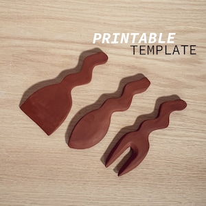 May include: Printable template for three wooden kitchen utensils: a spatula, a spoon, and a fork. The utensils are brown and have a wavy design.