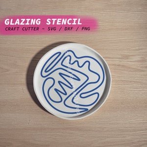 Puede incluir: Un plato de cerámica blanco con un diseño abstracto azul. El diseño es una serie de líneas curvas que crean un patrón único. El plato es perfecto para usar como plantilla para proyectos de manualidades.