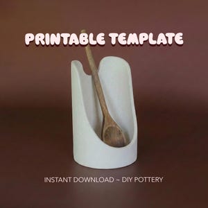 May include: A white ceramic spoon rest with a wooden spoon inside. The text "PRINTABLE TEMPLATE" is at the top, and "INSTANT DOWNLOAD ~ DIY POTTERY" is at the bottom.