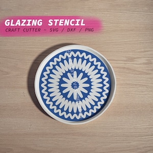 Peut inclure: Une assiette blanche avec un motif circulaire bleu et blanc. Le motif présente un motif répétitif de cercles blancs avec un bord ondulé et un centre bleu.