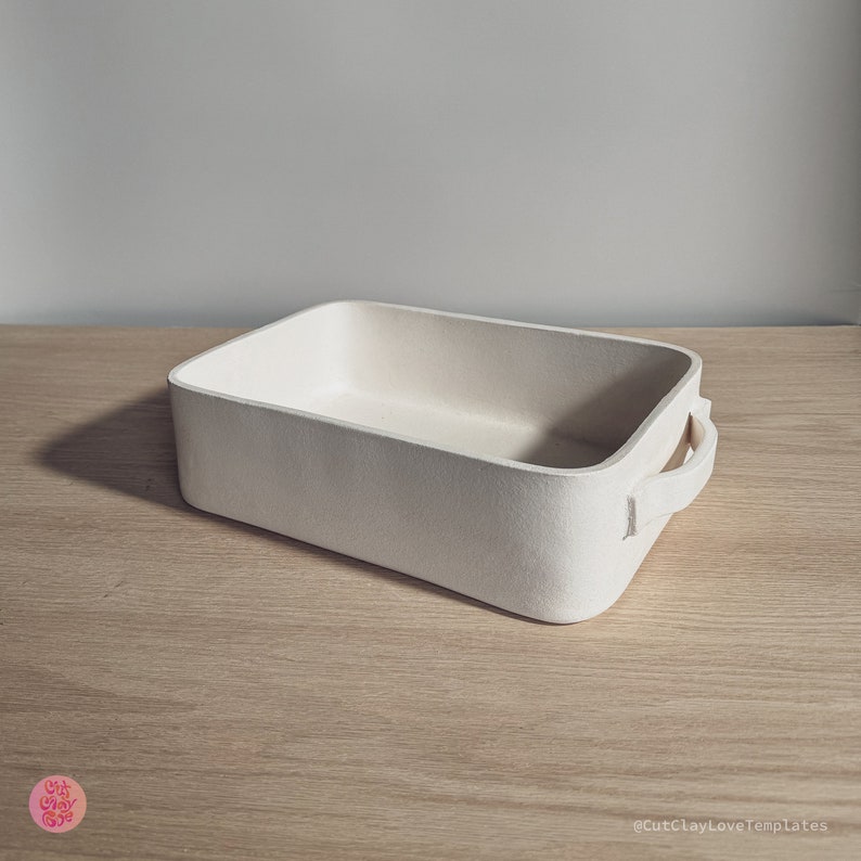 May include: A rectangular off-white baking dish with rounded corners and two side handles. The exterior and interior surfaces have a matte, textured finish. The text @CutClayLoveTemplates is visible in the bottom right corner of the image.