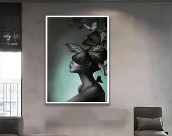 May include: A framed artwork featuring a woman's profile with butterfly-shaped elements. The artwork is primarily black and white with a teal background. The butterflies appear to be part of the woman's hair and surrounding her.