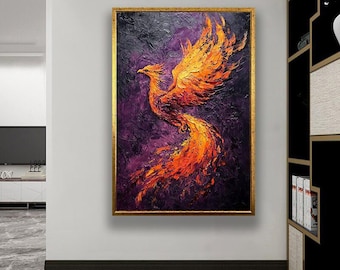 May include: A framed painting of a phoenix in flight. The artwork features a vibrant color palette of orange, yellow, and red against a dark purple and black background. The phoenix is depicted with outstretched wings and a flowing tail, set within a gold frame.