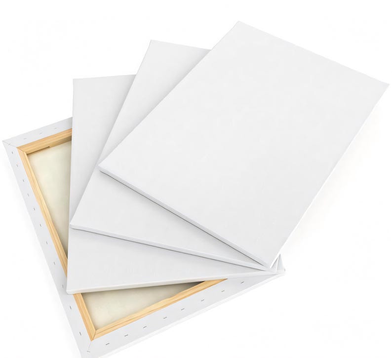a stack of white canvas boards or sheets, with one of them partially open, revealing a wooden frame.