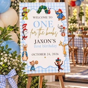 May include: A rectangular birthday sign on a wooden easel featuring a light blue gingham border and illustrations of storybook characters. The text reads: WELCOME TO ONE for the books JAXON'S first birthday OCTOBER 24, 2026.