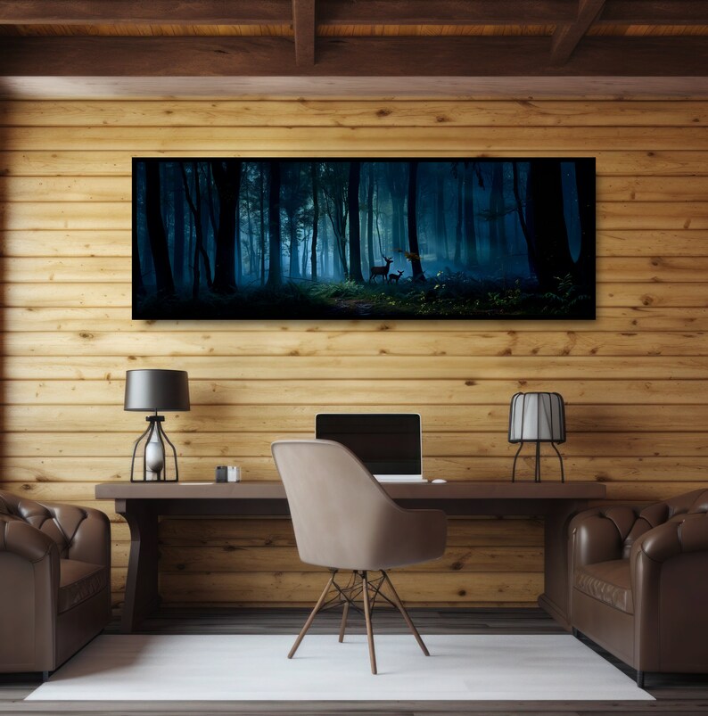 May include: A long, rectangular canvas print depicting a dark, misty forest scene with deer. The artwork hangs above a wooden desk with a laptop, two lamps, and a chair. The room has wood paneling and two leather armchairs.