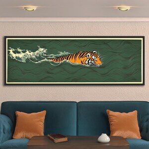 May include: A framed art print shows a tiger swimming in green water. The tiger has orange and black stripes, with white accents. White waves are on the left. The artwork is in a black frame. The print would look great in a living room.