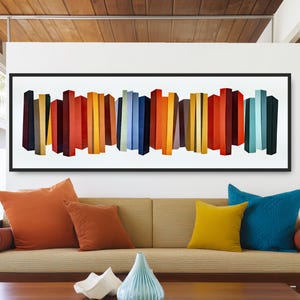 May include: Abstract art print with a series of colourful vertical rectangular shapes in shades of red, orange, yellow, blue, and green. The artwork is framed in black and hangs above a beige sofa with orange, yellow, and blue cushions.