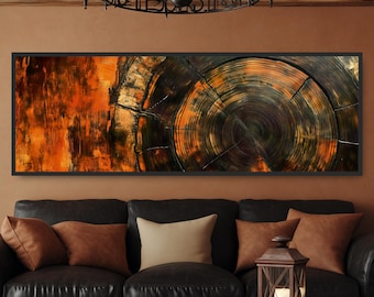 May include: A framed artwork featuring a close-up of a tree trunk cross-section. The artwork showcases concentric rings in shades of orange, brown, and black, with visible cracks and textures. The piece is displayed above a black leather sofa.