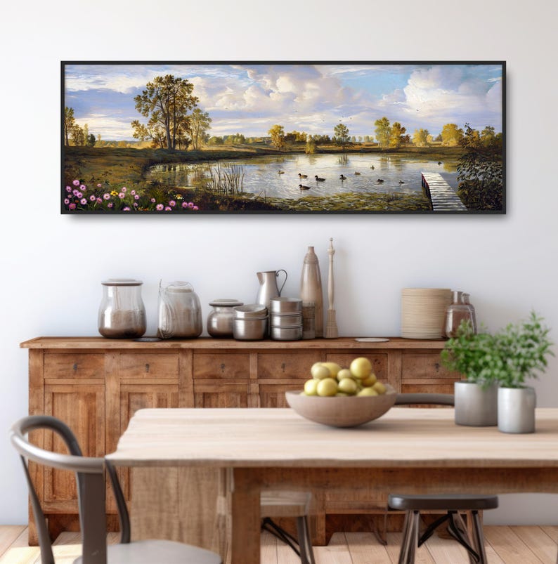 May include: A panoramic landscape painting depicting a serene lake with ducks swimming in the water. The lake is surrounded by lush green trees and a wooden dock extends into the water. The sky is a bright blue with fluffy white clouds.
