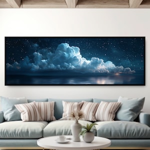 May include: A panoramic photograph of a dark blue ocean with a starry night sky and fluffy white clouds. The clouds are illuminated by the moon, creating a soft glow over the water.