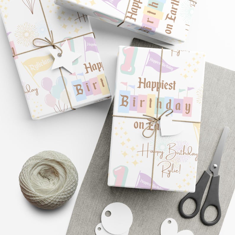 May include: Gift-wrapped presents with birthday-themed wrapping paper. The paper features pastel colors, flags, balloons, and the text "Happiest Birthday on Earth" and "Happy Birthday Rylie!". Presents are tied with twine and star-shaped tags.