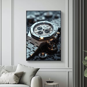 May include: A silver chronograph wristwatch with a white face and black accents. The watch is lying on a black surface with water droplets on it.
