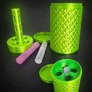 May include: A neon green container set with a diamond pattern, featuring a cylindrical storage unit, a base with multiple holes, and two smaller tubes. The set includes a lid and a stand. The objects are arranged on a dark surface.
