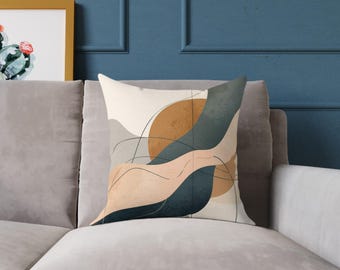 Puede incluir: Cojín cuadrado con un diseño abstracto. El cojín presenta un fondo beige con un gran círculo marrón y formas fluidas en tonos de verde azulado y melocotón. Finas líneas negras añaden detalles al diseño.