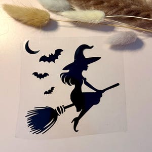 Peut inclure: Un autocollant en vinyle noir représentant la silhouette d'une sorcière portant un chapeau pointu et chevauchant un balai. Le motif comprend trois petites chauves-souris en vol et un croissant de lune placés à gauche de la sorcière.