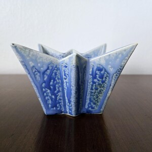 May include: A blue and white ceramic star-shaped dish with a textured glaze.