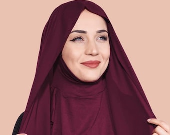 Puede incluir: Un hiyab de color burdeos con un diseño largo y fluido. El hiyab está hecho de una tela suave y elástica, perfecto para el uso diario.