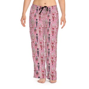 May include: Pink pajama pants with a repeating pattern of nutcracker soldiers and snowflakes.
