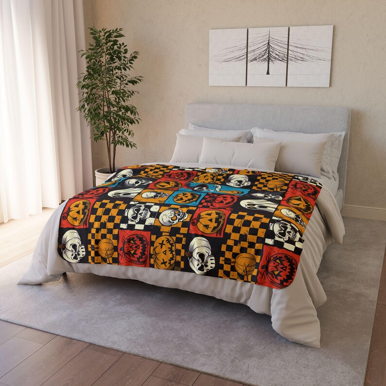 May include: A Halloween-themed throw blanket with a patchwork design featuring orange and black pumpkins, skulls, and chequered patterns.