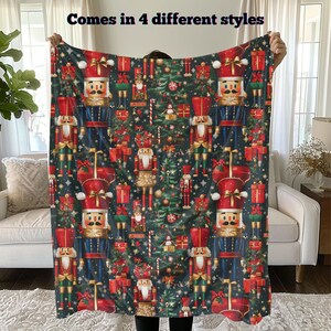 May include: A colorful throw blanket featuring a repeating pattern of nutcracker soldiers, Christmas trees, and candy canes. The text "Comes in 4 different styles" is printed at the top of the blanket.