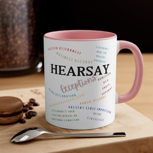 May include: A pink and white coffee mug with the word "HEARSAY" in black text and the word "Exceptions" in a colorful font. The mug features a list of legal exceptions to the hearsay rule.