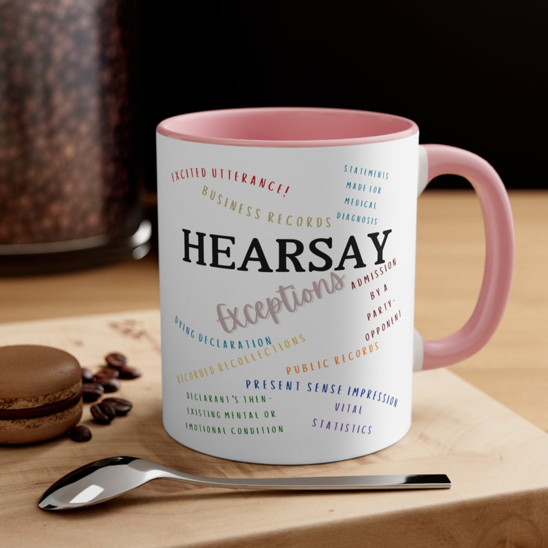 May include: A pink and white coffee mug with the word "HEARSAY" in black text and the word "Exceptions" in a colorful font. The mug features a list of legal exceptions to the hearsay rule.