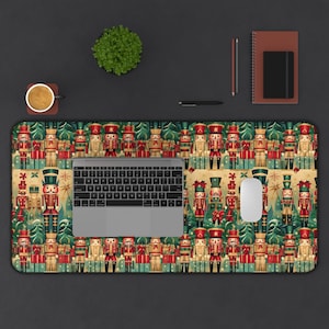 May include: A green, red, and gold mousepad with a repeating pattern of nutcracker soldiers holding presents and standing in front of Christmas trees. A laptop computer and a white wireless mouse are on the mousepad.