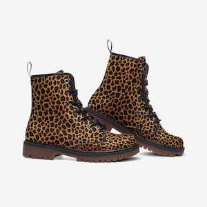 May include: A pair of brown and black leather boots with a leopard print design. The boots have laces and a thick sole.