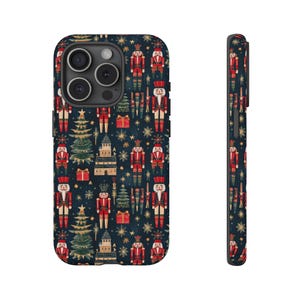May include: A phone case with a dark blue background and a repeating pattern of nutcrackers, Christmas trees, and gold stars. The nutcrackers are wearing red and gold uniforms.