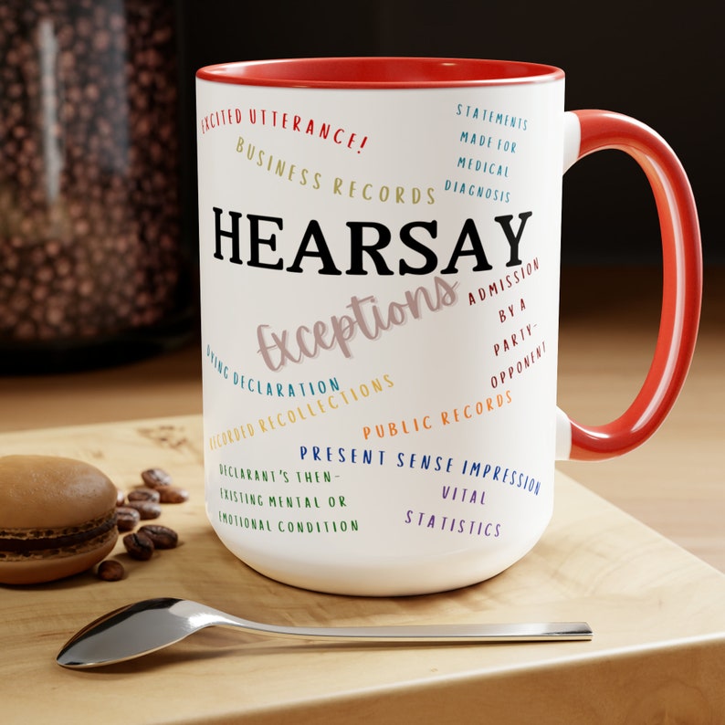 May include: White ceramic mug with a red rim and handle. The mug features the word "HEARSAY" in black text and the word "Exceptions" in pink text. The mug is surrounded by a variety of legal terms related to hearsay exceptions, including "Excited Utterance", "Business Records", "Statements Made for Medical Diagnosis", "Admission by a Party-Opponent", "Dying Declaration", "Recorded Recollections", "Public Records", "Present Sense Impression", "Declarant's Then-Existing Mental or Emotional Condition", and "Vital Statistics".