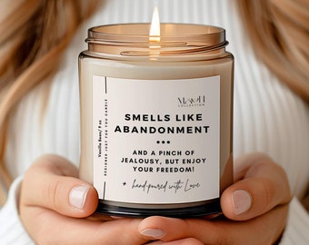 May include: A brown glass candle with a white label that reads "Smells Like Abandonment... And a pinch of jealousy, but enjoy your freedom! + hand-poured with love".