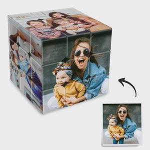 Op de afbeelding: Een gepersonaliseerde fotocube met meerdere familiefoto's. De kubus toont afbeeldingen van een vrouw, een baby en andere familieleden. Een uniek cadeau-idee.