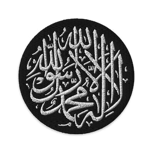 Könnte beinhalten: Ein gestickter Patch in Schwarz und Weiß mit dem islamischen Satz "Es gibt keinen Gott außer Allah, und Muhammad ist der Gesandte Allahs" in arabischer Schrift.