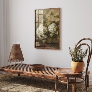 May include: A framed vintage botanical print of white hydrangeas in a vase, displayed on a white wall above a wooden bench and a small wooden stool.