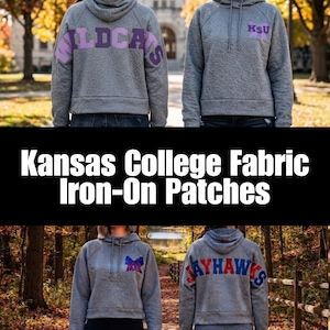 May include: Grey hooded sweatshirts featuring iron-on patches. One displays the word WILDCATS in purple on the back and KSU on the front. Another shows JAYHAWKS in red and blue on the back with a bow-shaped patch on the front chest area.