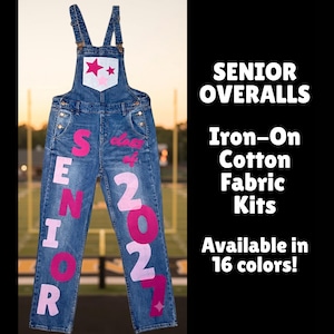 May include: Blue denim overalls featuring pink and light pink iron-on fabric letters spelling SENIOR and the numbers 2027. The chest pocket displays two pink stars, and the text SENIOR OVERALLS Iron-On Cotton Fabric Kits Available in 16 colors!