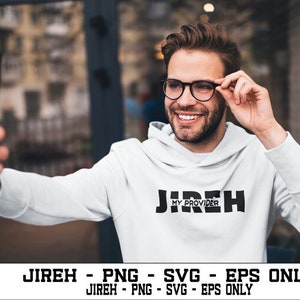 May include: A person wearing a white hoodie with the text "Jireh My Provider" in black letters. The person is smiling and holding a smartphone in their right hand.