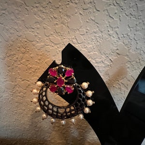 May include: Black and gold earrings with pink and black gemstones and white pearls.