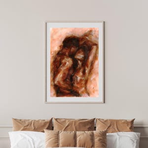 May include: Abstract painting in a light wood frame. The artwork depicts two figures in shades of brown and orange, with visible brushstrokes. The painting is mounted above a bed with brown and white pillows.