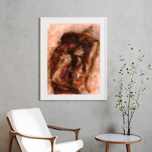 May include: Abstract painting in a white frame. The artwork depicts two figures in a warm color palette of browns and oranges. The figures are intertwined, suggesting intimacy. The painting is displayed in a modern interior setting.