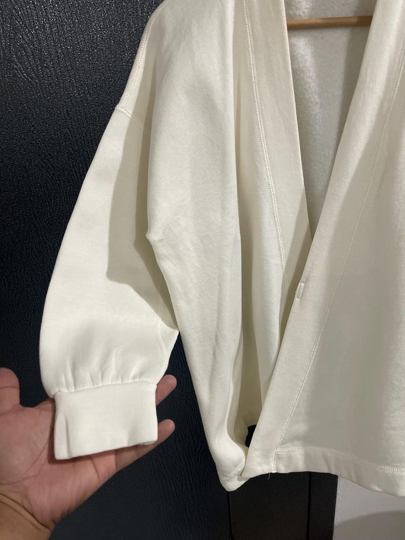 Pu&ograve; includere: Cardigan color crema con maniche lunghe e vestibilit&agrave; morbida. Il cardigan presenta uno scollo a V e una chiusura con bottoni. Le maniche hanno polsini a coste. Il tessuto sembra essere un materiale morbido e confortevole.