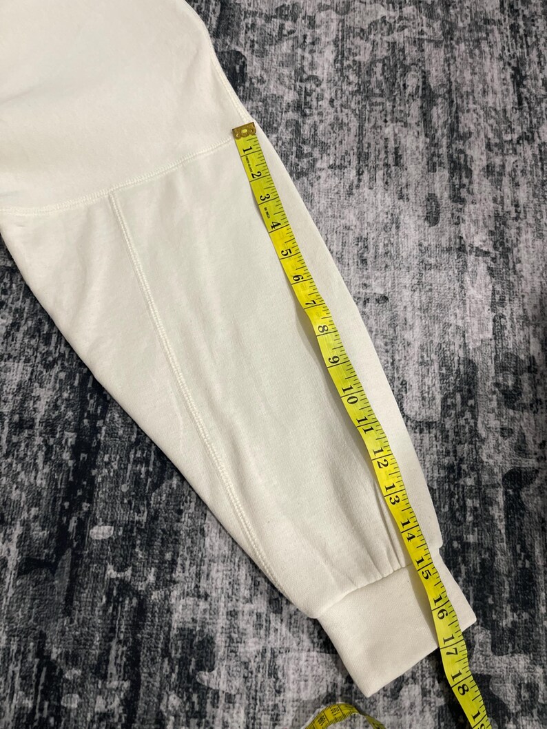 Pu&ograve; includere: Manica di felpa color crema con un metro a nastro giallo. Il nastro mostra una misura di circa 45 cm. La manica &egrave; realizzata in un materiale morbido e spesso.