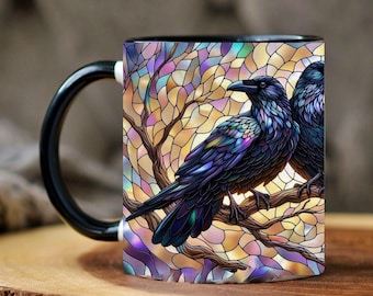 May include: Black coffee mug with a raven design. The raven is perched on a branch against a stained-glass style background with purple, blue, and yellow hues. The mug has a black handle and rim.