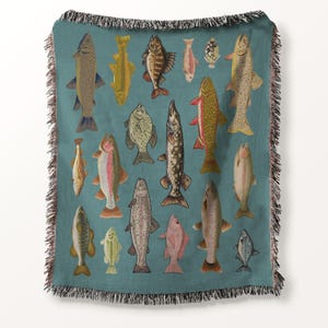 May include: Teal throw blanket featuring a pattern of various fish illustrations in shades of brown, yellow, pink, and gray. The blanket has a fringed edge and is suitable for home decor.