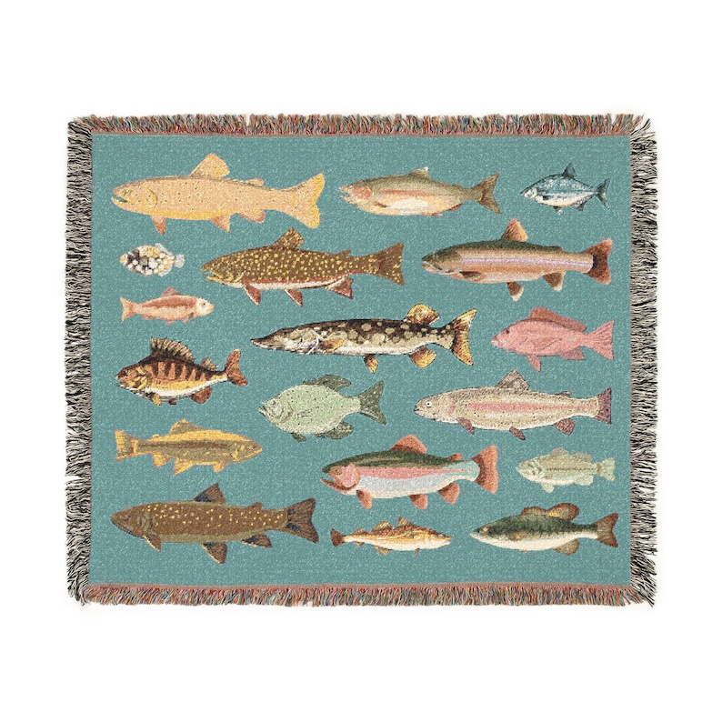 May include: A woven throw blanket featuring a teal background with various fish illustrations in shades of brown, yellow, and pink. The blanket has a fringed edge and is designed with a repeating pattern of different fish species.