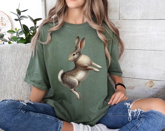 May include: A green t-shirt with a graphic of a brown rabbit standing on its hind legs.